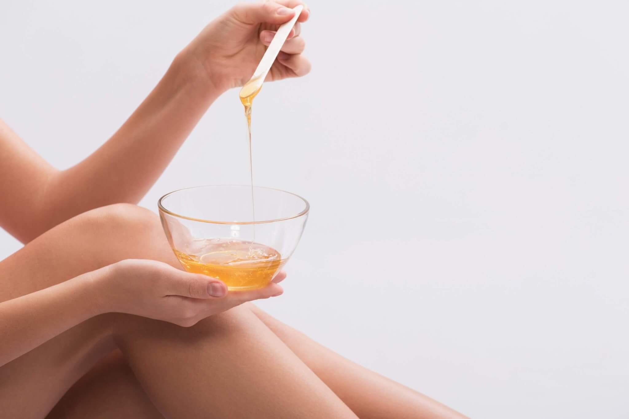 woman hand holding waxing stick with wax dripping